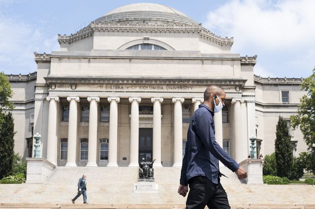 People walking across Columbia University's campus wearing face masks during the COVID-19 pandemic.